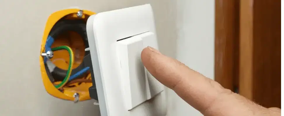 Interrupteur va et vient étant poussé par un doigt.