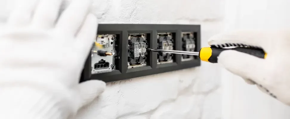 Installation de prises encastrée dans un mur blanc.